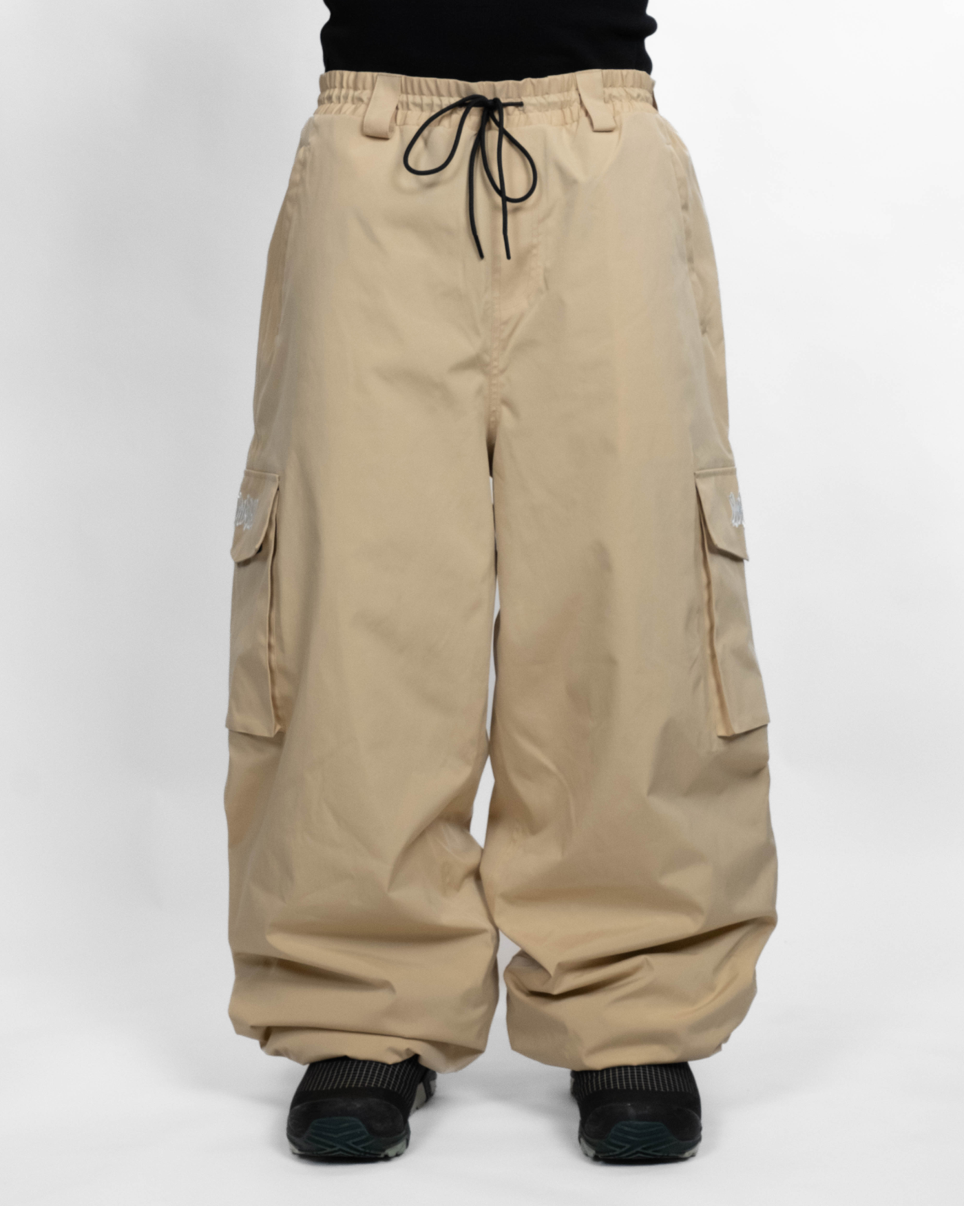 Beige baggy snowpants front view on model (The model is 180cm wearing size XL)