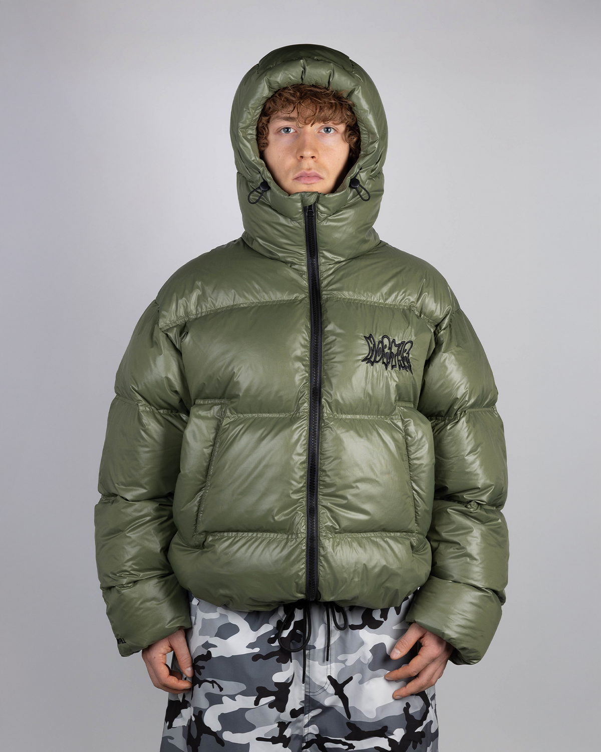 Green puffer jacket on model hooded front view
